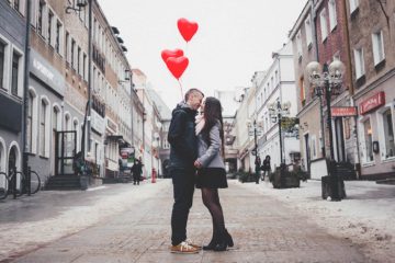 Koppel op straat met hartjes balonnen